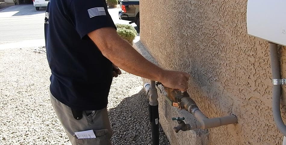 Brass backflow assembly serviced against a Tucson stucco wall